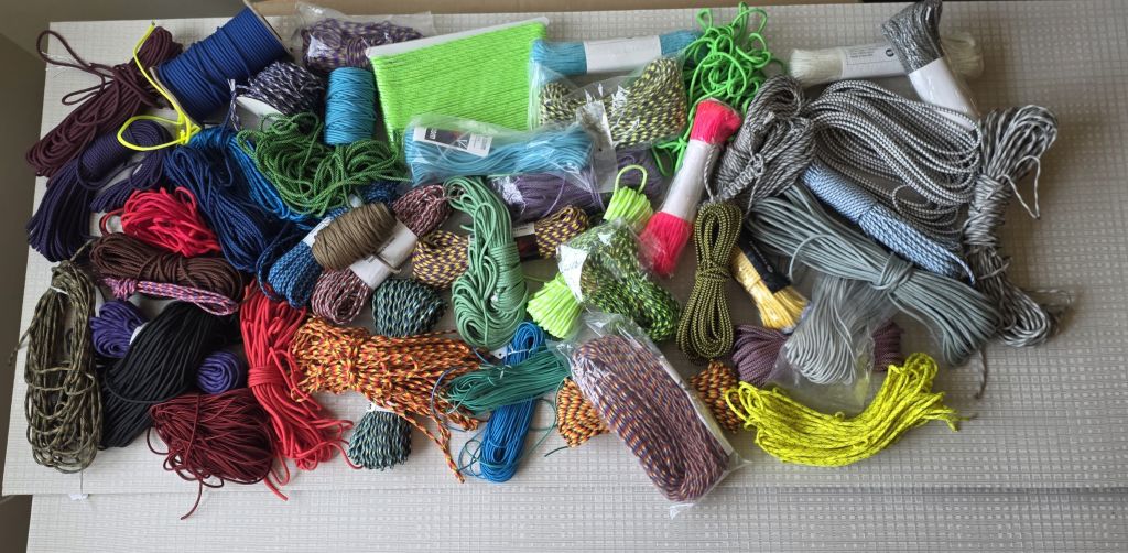 Paracord inventory spread across a cutting mat showing full range of colors and patterns